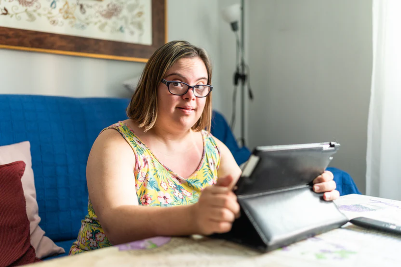 girl with down syndrome wearing a tropical shirt on a tablet