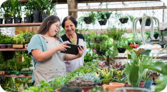 young adult with down syndrome using ipad as a daily support tool at work at a plant nursery