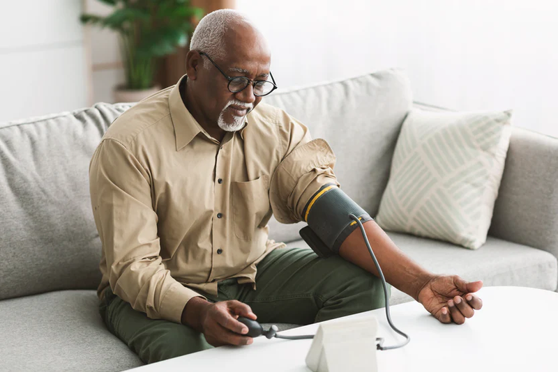 older black man using a digital health solution to measure his blood pressure at home